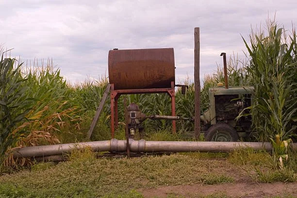Old rusty fuel tank sitting in a field.