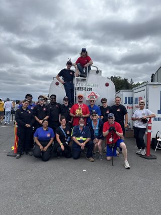 Snyder Green team gathered behind a fuel truck posing for a group photo.