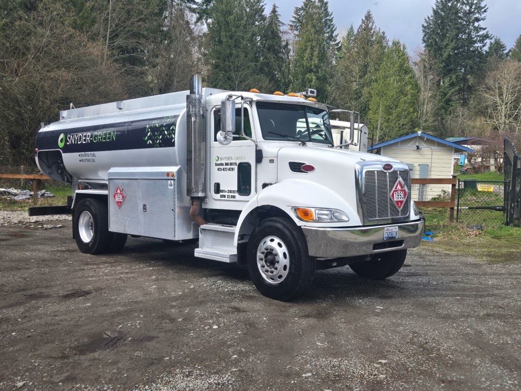 Snyder Green fuel truck parked on gravel in a residential area.